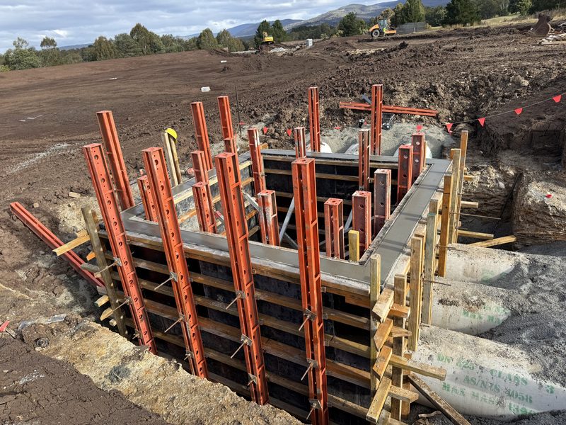 Freshly poured pit walls braced by steel soldiers and walers.