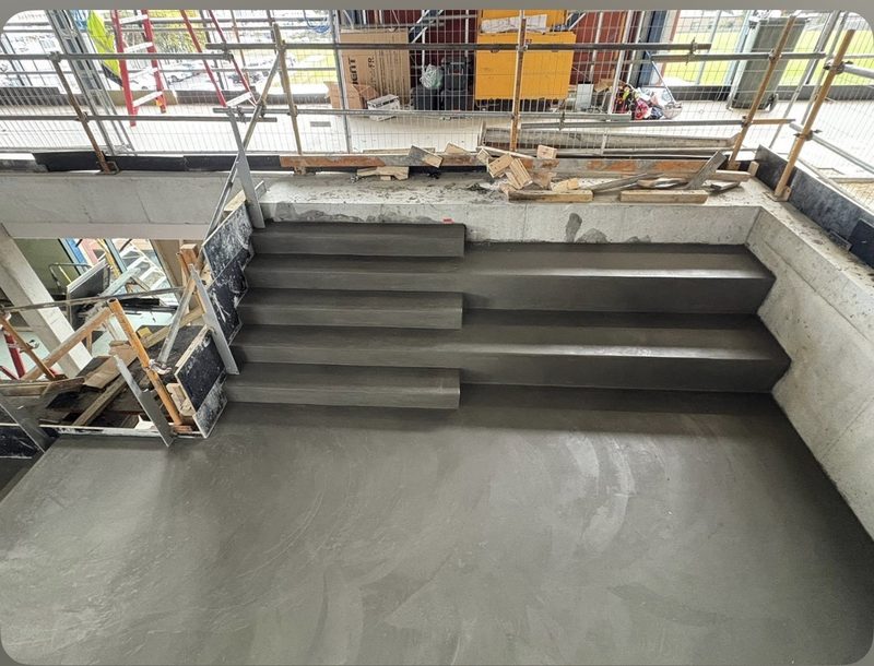 In-situ concrete steps formed into tiered seating with crisp nosings.