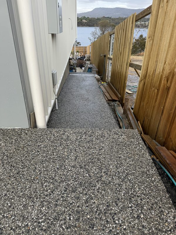 Exposed aggregate path running in one clean run from the house to the fence.