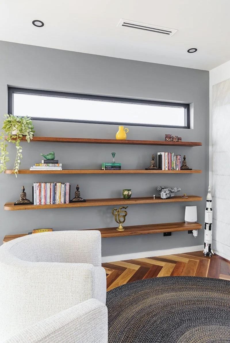 Four floating timber shelves on a grey wall